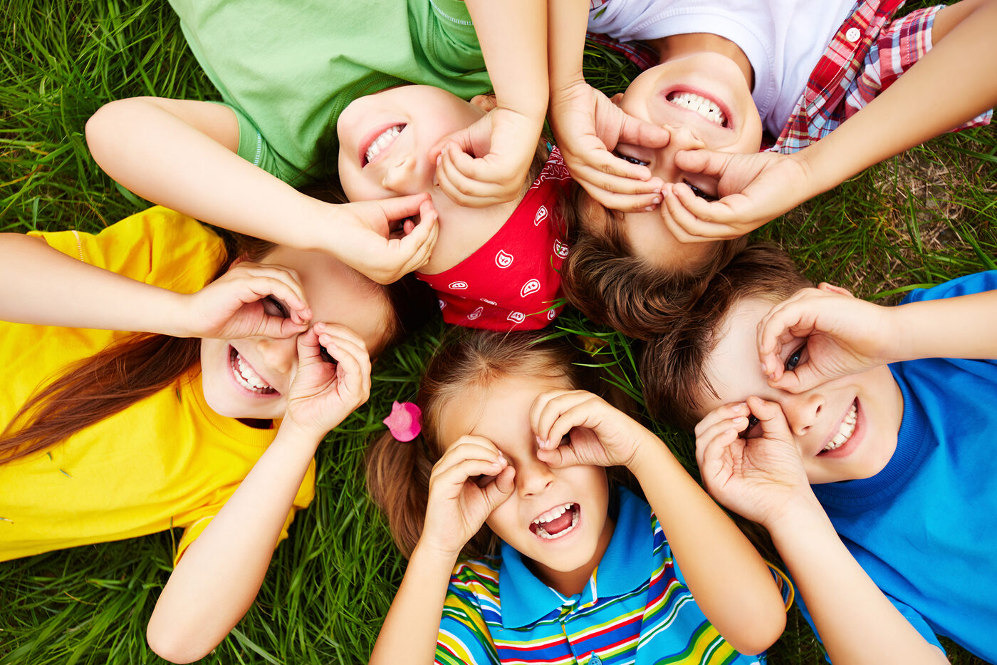 Children moving and playing together outdoors on the grass